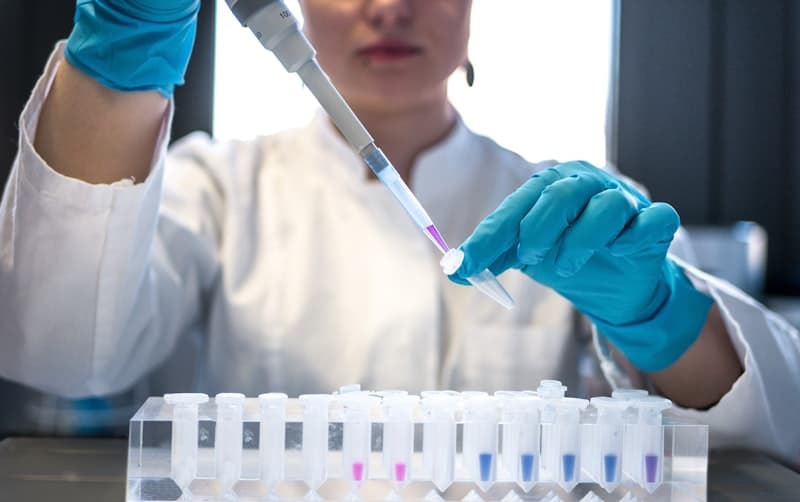 Researcher using a pipette in a biomedical research laboratory